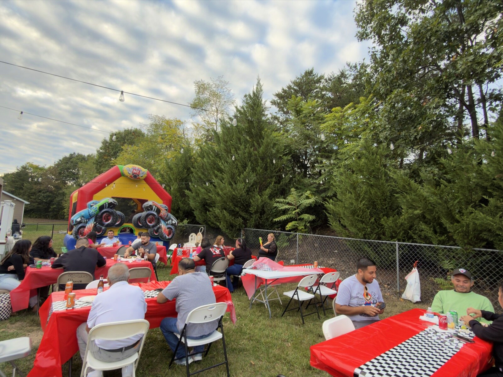 Red party tables and a colorful inflatable in the backyard