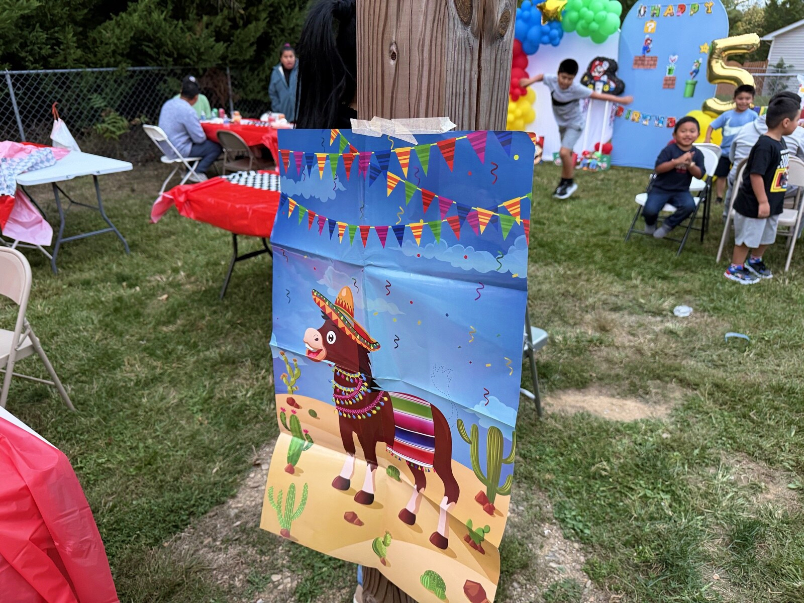 A colorful donkey game board with the party in the background
